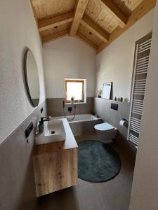 a bathroom with a sink and a toilet and a tub at Gams im Glück in Hopferau