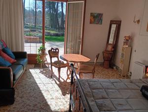 a living room with a table and chairs and a couch at Le toit d'éco pins in Le Luart