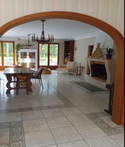 a living room with a table and a fireplace at Le toit d'éco pins in Le Luart