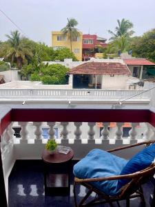 a balcony with a bed and chairs on a building at Le Clarisse Guest House in Pondicherry