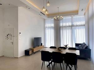 a living room with a table and chairs and a couch at Penthouse à Manhattan Netivot in Netivot