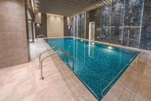 a swimming pool with blue water in a building at Grand Iva Hotel Abha in Abha