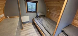 a small bedroom with a bed in a tiny house at Wyreside Lakes Glamping Pods in Lancaster