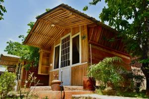 a small wooden house with a white door at Làng Hương Village in Teurnoum