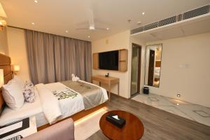 a hotel room with a bed and a tv at The Park Inn in Jhārsuguda