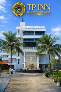 a building with palm trees in front of it at The Park Inn in Jhārsuguda