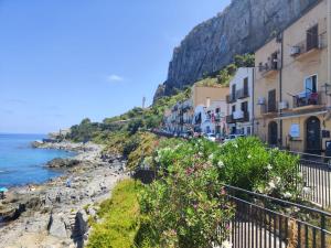 a group of buildings on a hill next to the ocean at Scinniamare in Cefalù