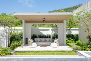 an outdoor patio with a couch and a table at Nature's Rest Private Pool Villa Rawai in Rawai Beach