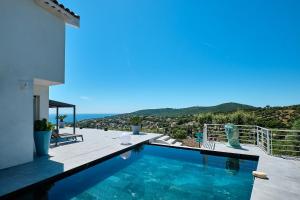 a house with a swimming pool with a view of the ocean at Villa 259 in Roquebrune-sur-Argens