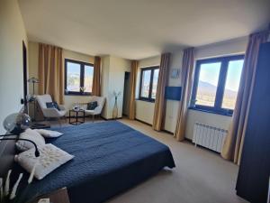 a bedroom with a blue bed and some windows at Apartments Terra Harmony - 4 star free SPA resort, Golf i Skiing in Bansko +114 photos