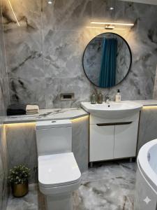 a bathroom with a sink and a toilet and a mirror at Main Street House in Chişinău