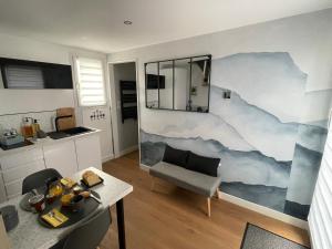 a living room with a painting on the wall at Appartement proche Zenith & Polyclinique in Nantes