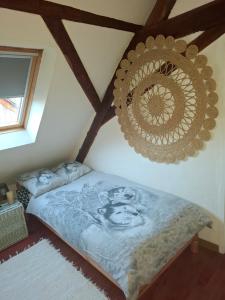 a bed in a room with a wooden ceiling at Maison Les Géraniums parking privé in Linthal