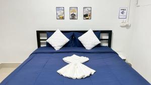 a blue bed with two white towels on it at SP House Khao Sok in Khao Sok National Park
