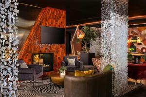 a lobby with chairs and a fireplace and a tv at Protea Hotel Fire & Ice by Marriott Cape Town in Cape Town