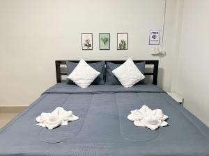 a blue bed with two white towels on it at SP House Khao Sok in Khao Sok National Park