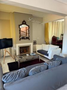 a living room with a couch and a fireplace at Villa Costa in Periyiálion