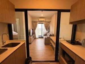a kitchen with a door open to a living room at Xim Condo in Bangkok 20 mins to Asiantique in Ban Tha Hin