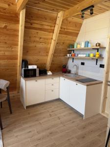 a kitchen with white cabinets and a wooden ceiling at Villa Silence in Žabljak +14 photos