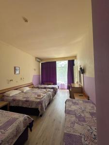 a hotel room with three beds and a window at Hotel RIVA in Golden Sands +21 photos