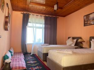 a bedroom with two beds and a window at Vila Llulla in Krujë