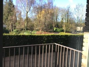 a view of a park with a fence and trees at La casa in Tielt