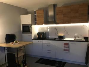 a kitchen with white cabinets and a sink and a counter at La casa in Tielt