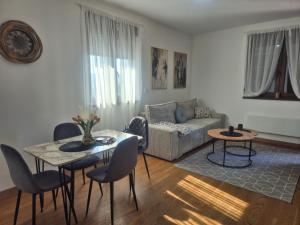 a living room with a couch and a table and chairs at Luna chalet Zlatibor in Zlatibor