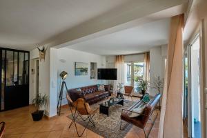 a living room with a leather couch and chairs at Villa 259 in Roquebrune-sur-Argens