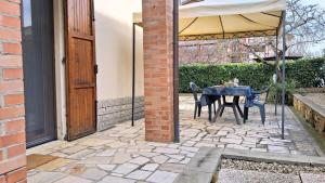a patio with a table and an umbrella at Maya Suite & Garden in Sarteano