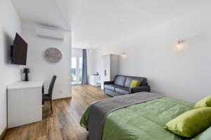 a bedroom with a bed and a desk and a couch at Luxea Guest House - B&B Treviso in Preganziol