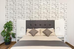 a bedroom with a large white bed with pillows at Luxea Guest House - B&B Treviso in Preganziol