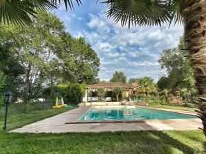 a swimming pool in a yard with a house at A Soulas in Armous-et-Cau