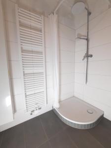 a white bathroom with a shower and a toilet at Hafenblick in Kiel
