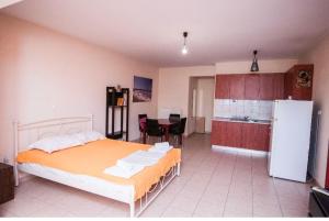 a bedroom with a bed and a kitchen with a refrigerator at Ypsipyli in Myrina