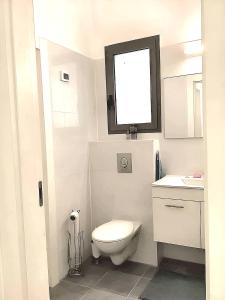 a white bathroom with a toilet and a sink at Penthouse à Manhattan Netivot in Netivot +30 photos