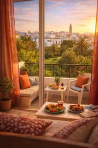 a room with a balcony with a view of a city at Dar El Amen Appartements in Mahdia
