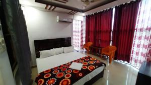 a bedroom with a bed and a table and chairs at Hotel Rajganga in Gonda