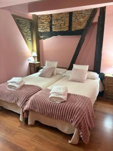 two beds sitting next to each other in a bedroom at La Carbonería in Béjar