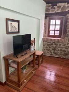 a living room with a tv and a wooden table at La Carbonería in Béjar
