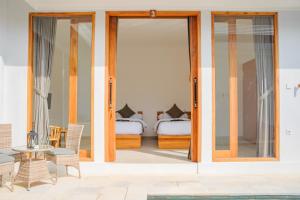 a room with sliding glass doors and a bedroom with a bed at Dolphin - New luxury rooms in Lovina Centre & near the beach in Lovina +70 photos