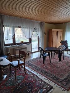 a living room with a table and chairs and a piano at Wasgau Urlaubserlebnis Fels und Seen in Ludwigswinkel