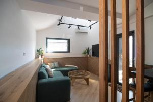 a living room with a green couch and a table at Three Peaks Thermal Villas in Banya