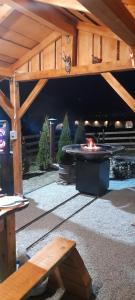 a patio with a fire pit under a wooden roof at La Ianis in Vatra Dornei