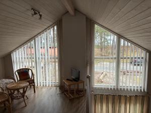 a room with large windows and a table with a television at Ferienhaus Baabe in Baabe