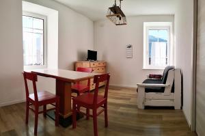 a dining room with a table and chairs and a chair at Camera con bagno privato in Tesero +14 photos