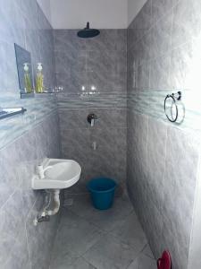 a bathroom with a sink and a blue bucket at Munaa House Wiyoni in Lamu +29 photos