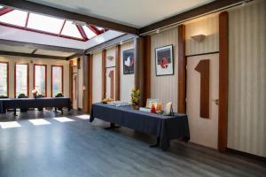 a room with tables with a number one on the wall at The Originals City, Hôtel Ascotel, Lille Est Grand Stade in Villeneuve d'Ascq