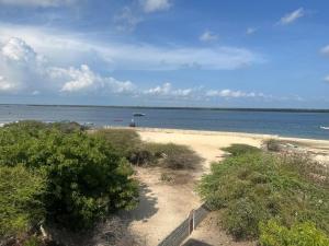 a view of a beach with a boat in the water at Munaa House Wiyoni in Lamu