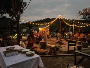 a group of people sitting under a tent with lights at Phayam Paradise Resort in Ko Phayam
